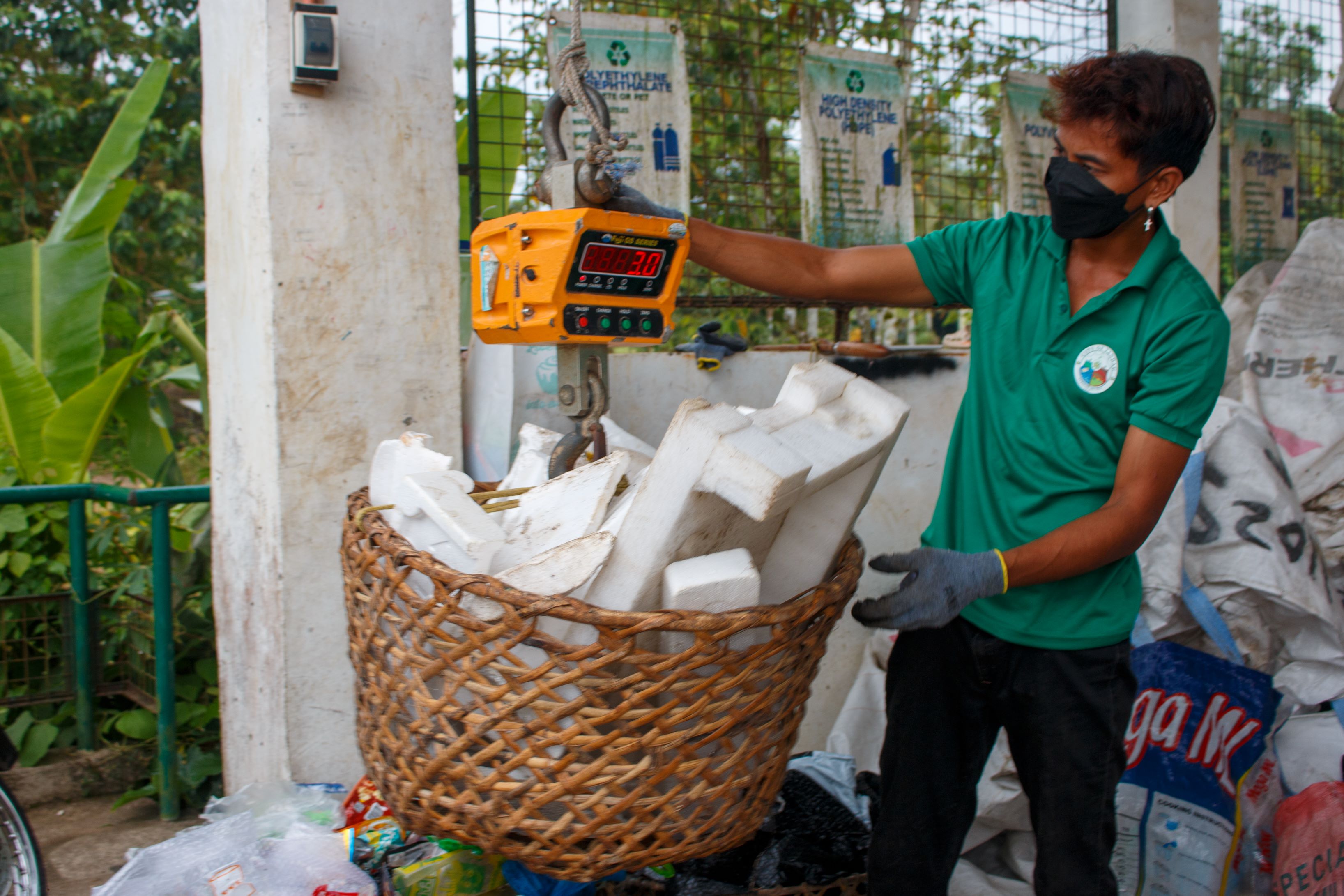 Waste workers sort plastics at the city’s Residual Containment Area .
