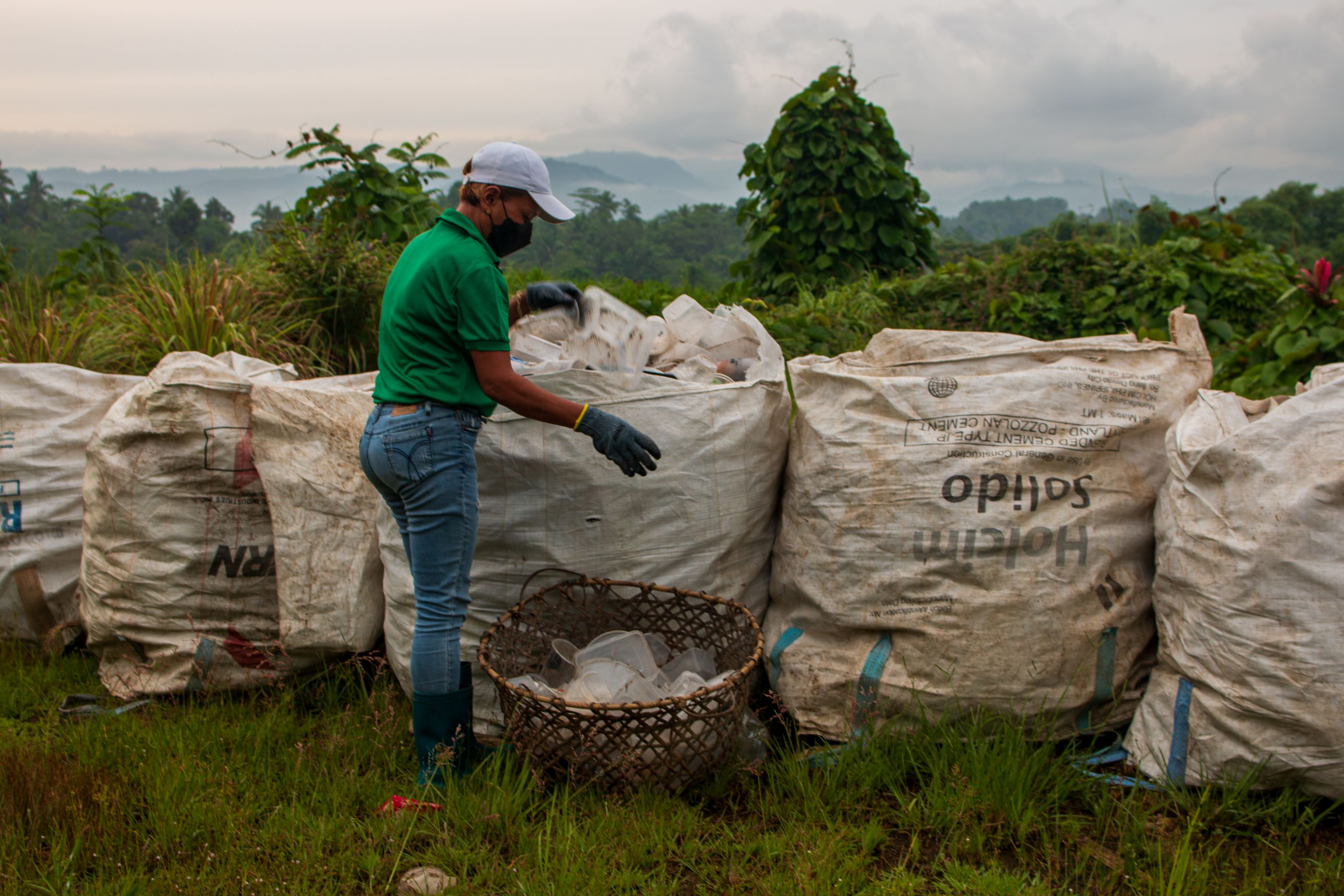 Waste workers sort plastics at the city’s Residual Containment Area .